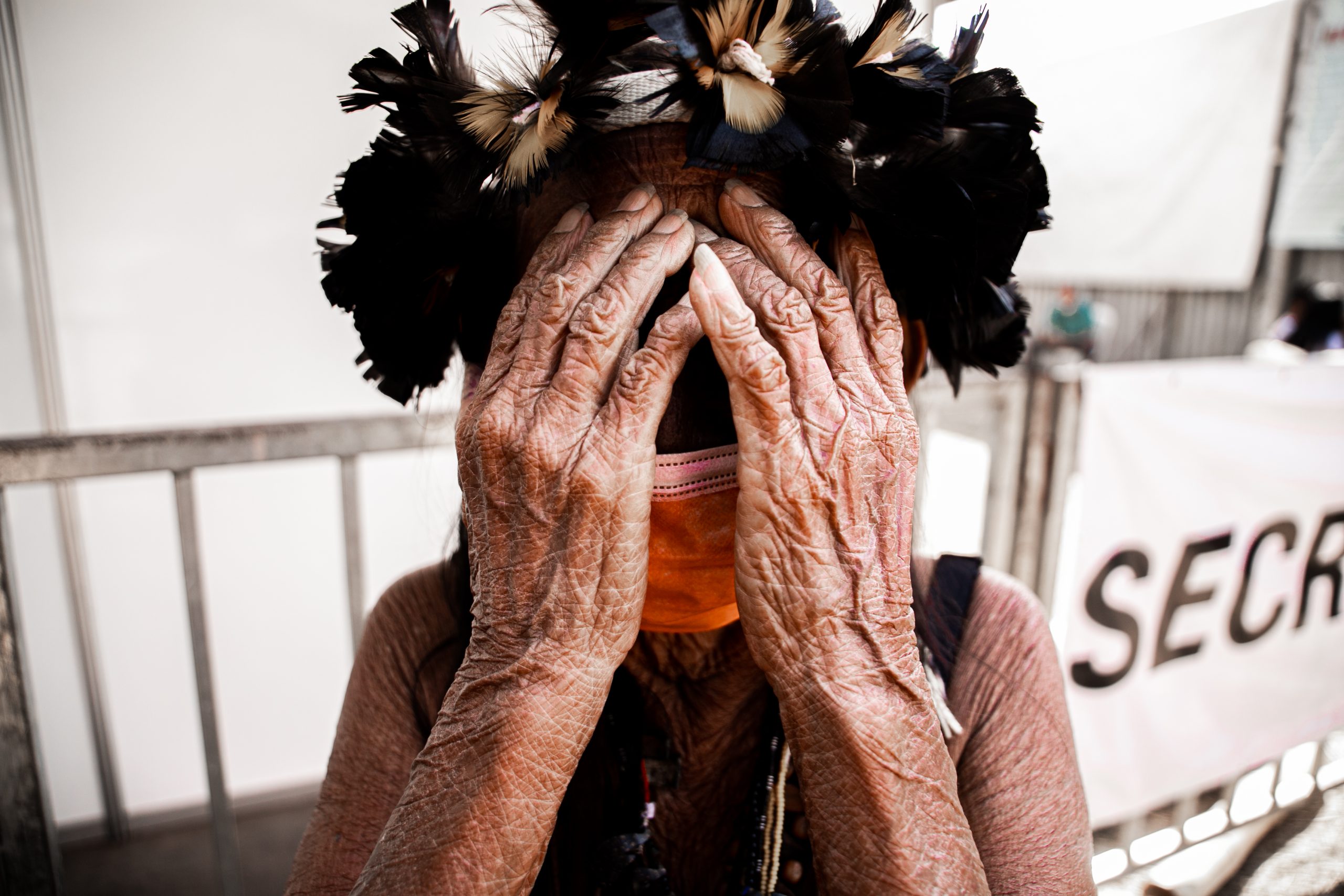 Mujer indígena cubriendo su rostro